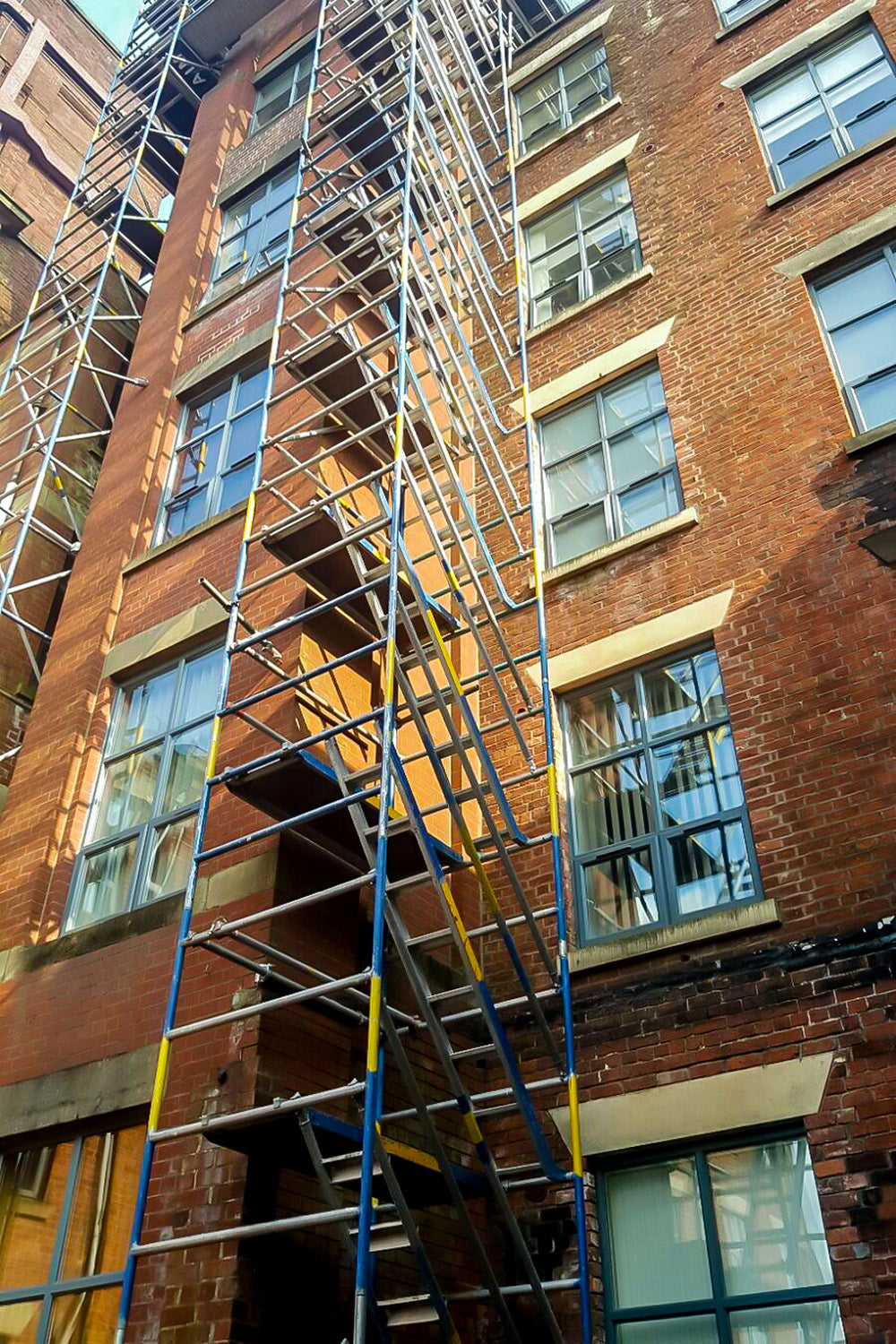 A tall Alto HD Stair Tower built against a block of flats.