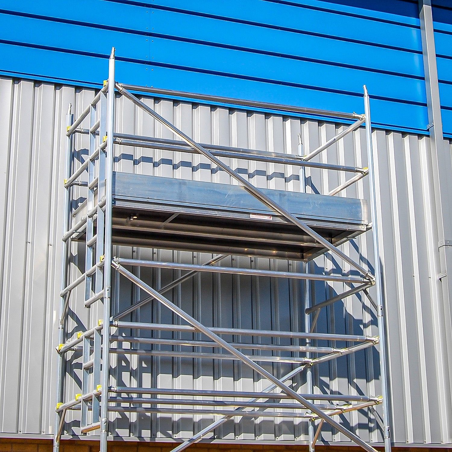 A double width Alto MD access tower against a silver and blue metal-clad building.