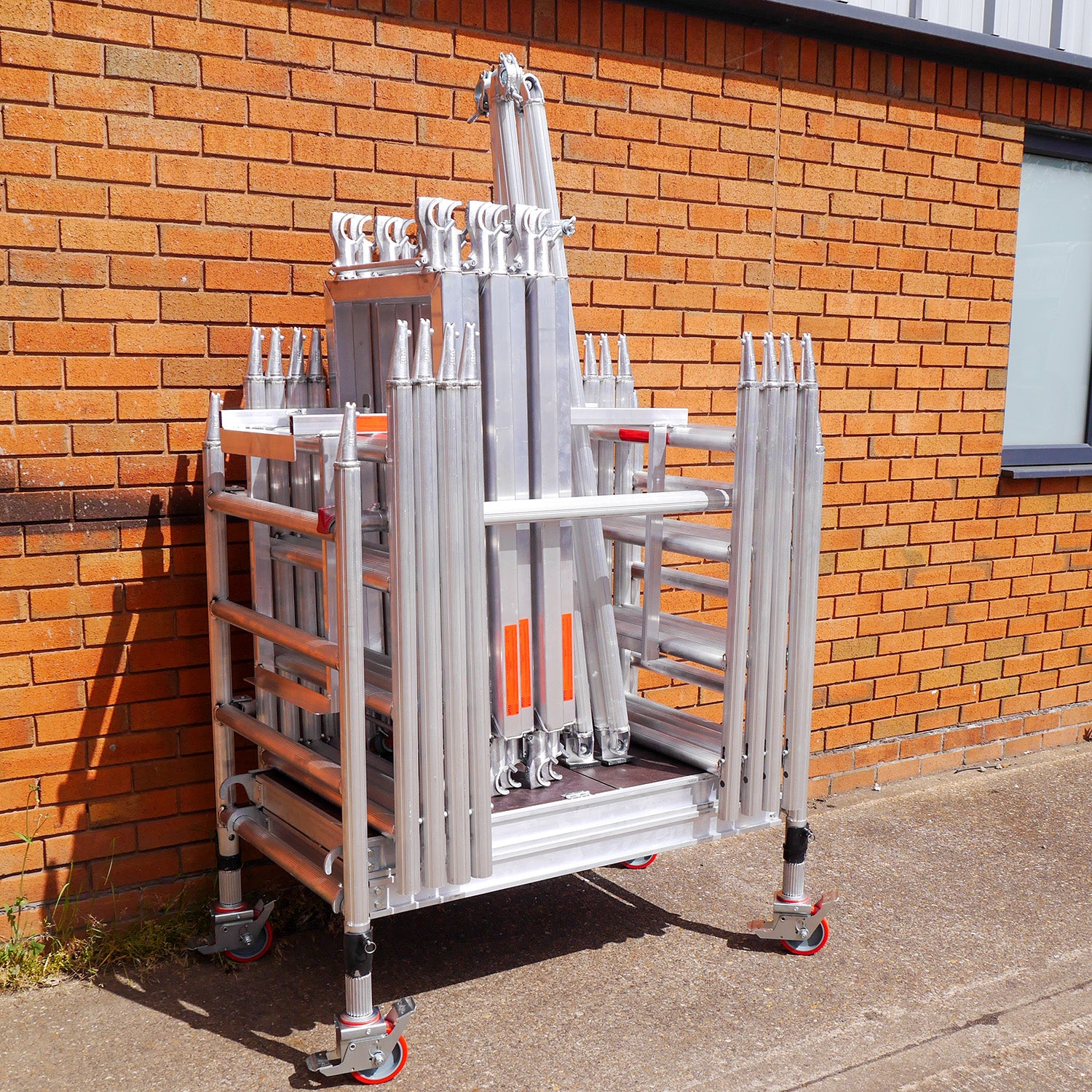 A photo of the Alto Mini Tower packed in its trolley, next to a brick building.