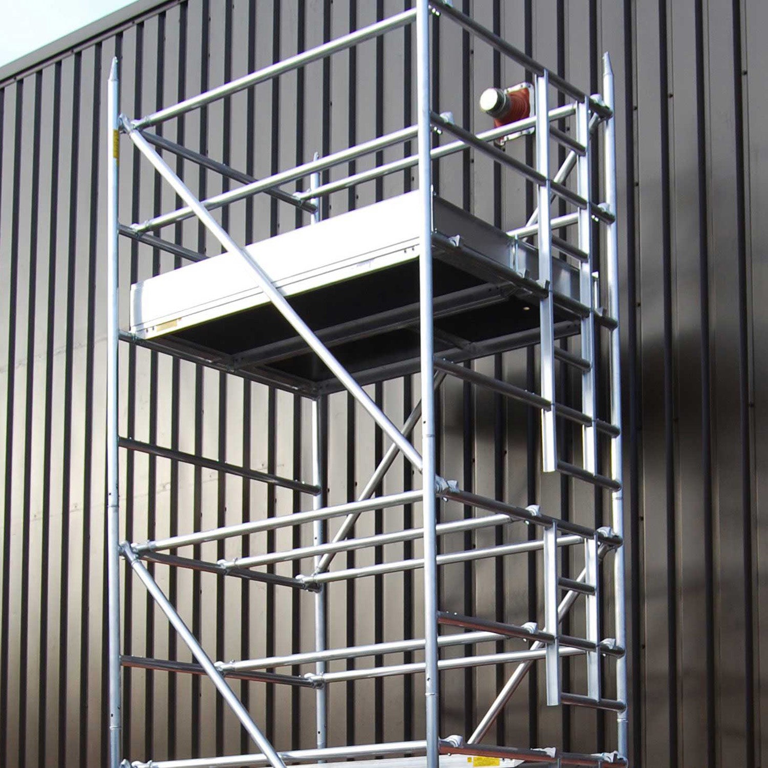 A double width Alto HD access tower against an metal-clad building.