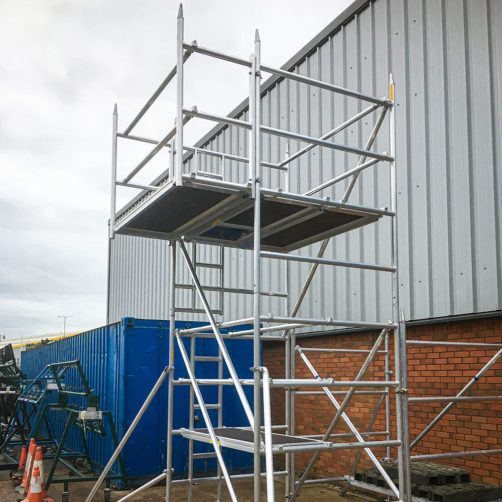 A photograph of a cantilever tower next to an industrial building.
