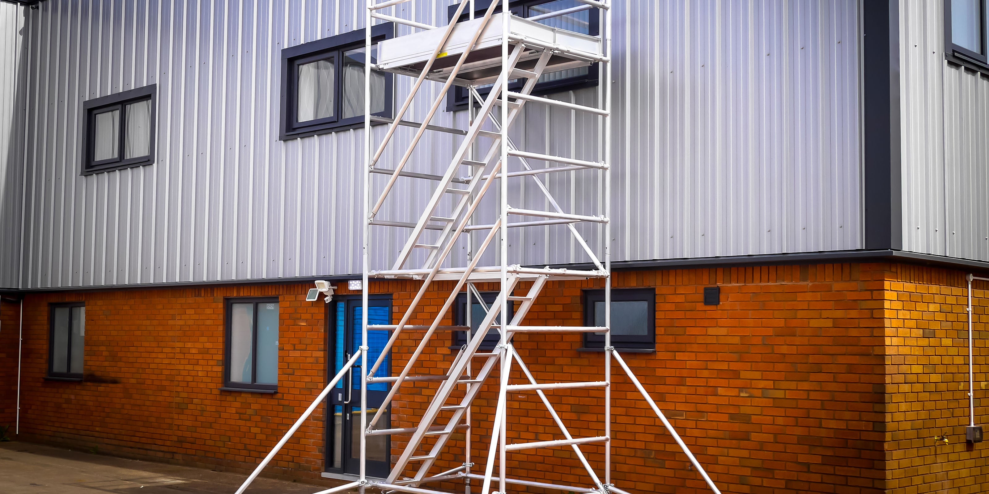ALTO HD Stair Tower against a building with silver cladding.